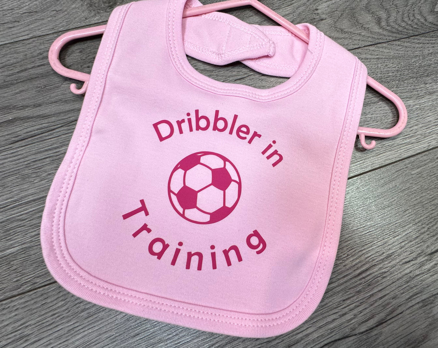 'Dribbler in training'' slogan pink baby bib